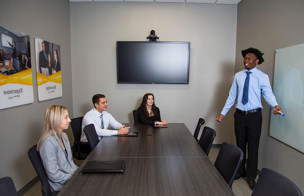 Students practice a mock presentation during a marketing course.